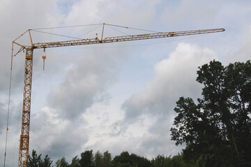 Yellow construction crane against cloudy sky