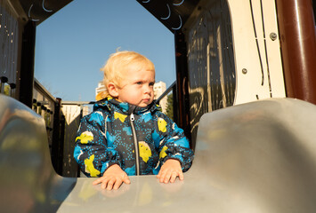 A small child on a playground in a park.