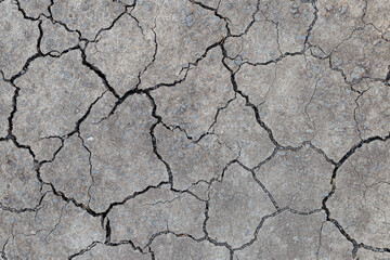 Close-up of dry cracked soil showing natural erosion pattern, ideal for environmental themes,...