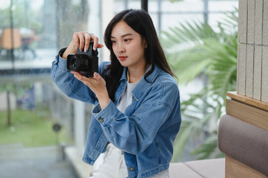 Young photographer checking photos on digital camera screen