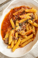 Closeup on penne pasta with veal tomato sauce and pecorino cheese