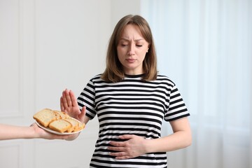 Gluten free diet. Woman refusing from bread indoors