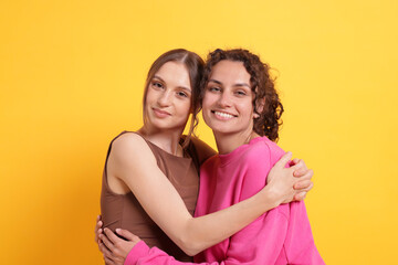 Friends hugging each other on orange background