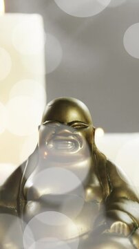 Animation of white light spots over buddha statue and candles