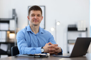 Portrait of handsome man at desk in office. Space for text