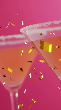 Animation of confetti falling and cocktail on pink background