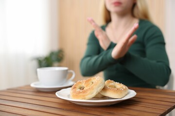 Gluten free diet. Woman refusing from pretzels indoors, selective focus