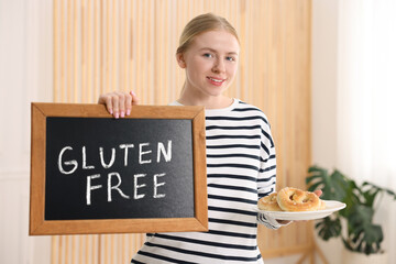 Woman holding small chalkboard with text Gluten Free and pretzels indoors