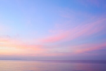Obraz premium Soft pastel hues paint the expansive sky above a tranquil ocean expanse during an ethereal dawn breaking across the horizon creating a serene and calming natural landscape view