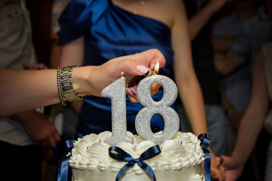 Lighting the number 18 birthday candles on a cake - Powered by Adobe