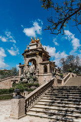 Obraz premium The ornate Cascada Monumental in Barcelona features elaborate sculptures and a golden chariot statue, viewed from the grand staircase below, Ciutadella Park