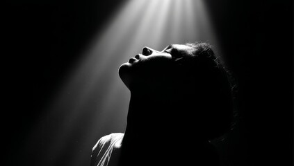 Silhouette of a Person Looking Upward in a Dramatic Spotlight
