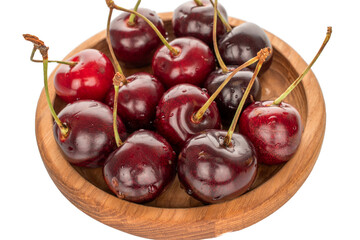 Sweet cherries on a wooden plate, macro.