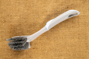 One dishwashing brush on a jute cloth, top view.