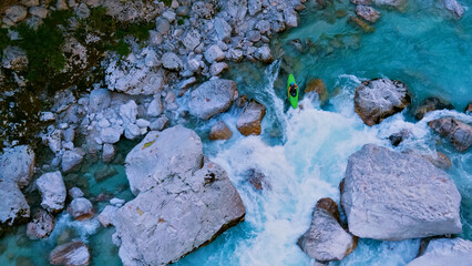 Kayaker navigates turquoise rapids in rugged terrain, showcasing nature's power and human daring. Captured from a bird's-eye view, this extreme adventure ignites adrenaline.