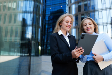 Two professionals discuss ideas while reviewing a digital document at an urban office complex on a...