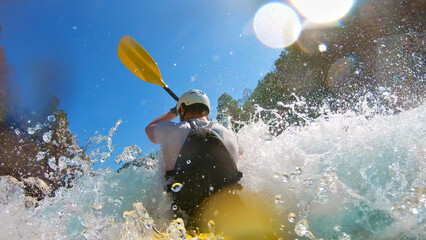 Adventurer battles roaring rapids in whitewater kayaking, adrenaline surging with each paddle...