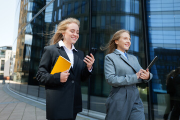 Two young professionals enjoying a sunny day while discussing digital trends and innovations...