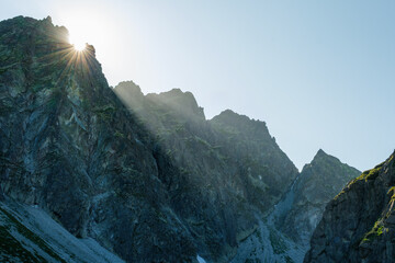 Sunset over high mountain ridge with sun rays ccoming through the mountains.  Dramatic and beautiful scene (High Tatras, Slovakia)