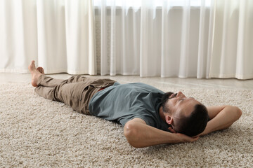 Harmony. Man lying on rug at home