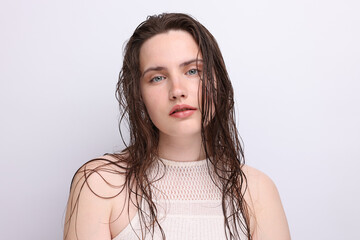 Portrait of beautiful woman with natural skin complexion on light grey background, closeup