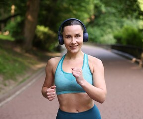 Sporty woman with headphones running in park