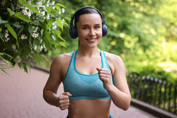 Sporty woman with headphones running in park