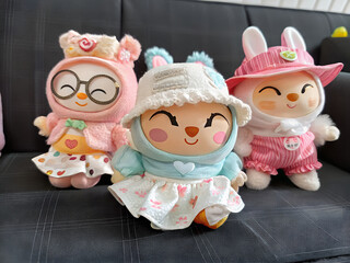 Three Adorable Plush Toys Sitting on Sofa