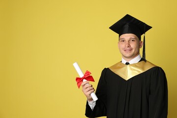 Happy student with diploma after graduation on yellow background. Space for text