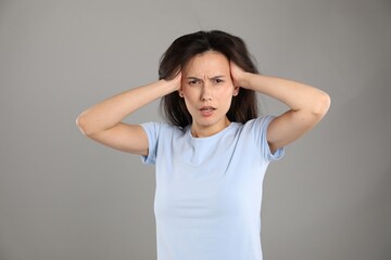 Portrait of shocked woman on grey background