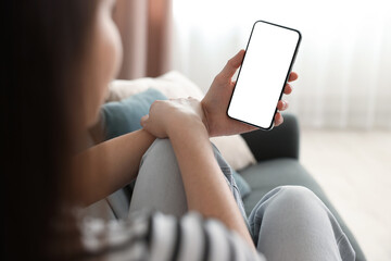 Woman using modern smartphone on sofa at home, closeup