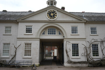 Shugborough, Staffordshire, England - February 24 2024: Historic white brick clock building with...