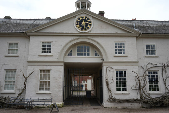 Shugborough, Staffordshire, England - February 24 2024: Historic white brick clock building with archway entrance. - Powered by Adobe