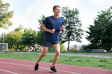 Sporty man running at stadium. Healthy lifestyle