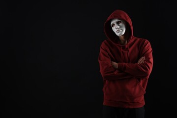 Anonymity. Man wearing mask on dark background, space for text