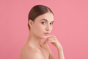 Naklejka premium Portrait of beautiful young woman on pink background