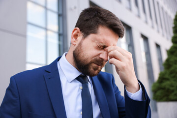 Portrait of tired businessman outside office building