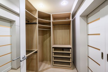 Bright room featuring an open wood closet and sliding white doors with bronze accents. Minimalist,...