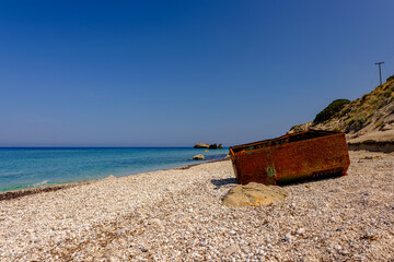 Rusty Industrial Container Washed Ashore on a Pebble Beach, Lefkada