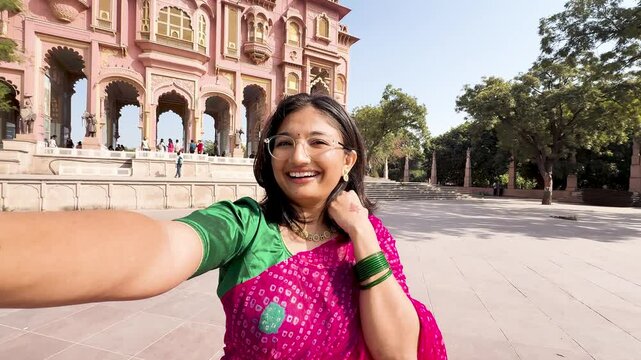 4K selfie video of young Indian woman wearing traditional Indian saree vlogging at Patrika gate in Jaipur, Rajasthan, India. Travel content creator making vlog. Travel blogger exploring architecture.