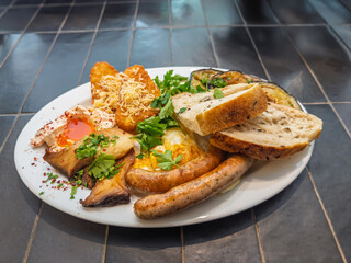 Appetizing breakfast spread with fried eggs juicy sausages crispy potatoes mushrooms fresh parsley...