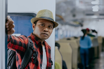 Asian man rides on the mrt train or subway. Urban transportation. Traveler man in a modern commuter...