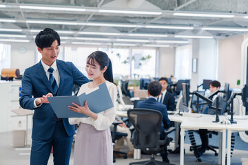 Fototapeta premium オフィスで先輩に相談をする若い女性