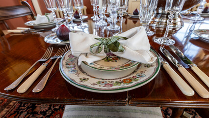 Elegant place setting awaiting guest on table with figs and crystal glasses