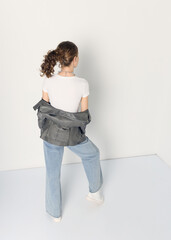 a woman dressed in accordance with fashion trends, in a leather jacket and a white top poses...