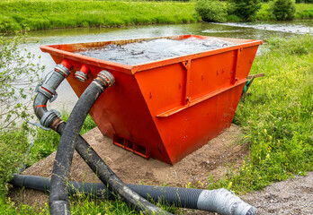 Water treatment tank near a river for waste management at a rural location during daylight hours