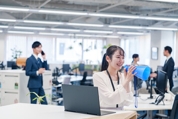 オフィスでメガホンを使って話す若い女性