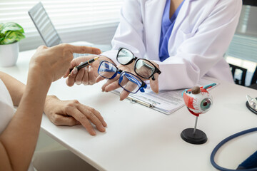 The ophthalmologist lets the patient choose the eyeglass frames that fit their face and sends them...