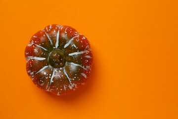 Halloween festive background. Orange pumpkin on color surface. Top view, space for text