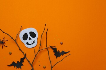 Halloween festive background design featuring bats, skull, spider and decorative branches